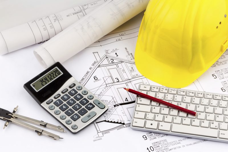 an architect's blueprint with construction helmet of a construction worker. symbolic photo for funding and planning of a new home.
