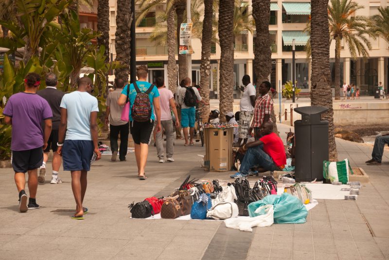 Torrevieja, Spain - July 26, 2012: Street scene with vendors and walkers on a windy day with scirocco winds, bringing red sand from the Sahara desert. Torrevieja, Costa Blanca, Spain on July 26, 2012.