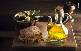 Olive oil with bread on a wooden table.