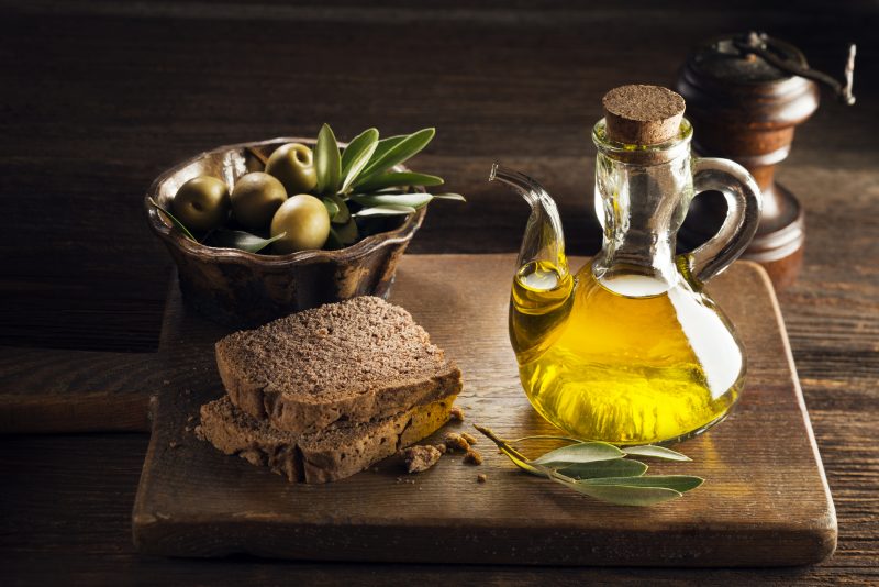 Olive oil with bread on a wooden table.